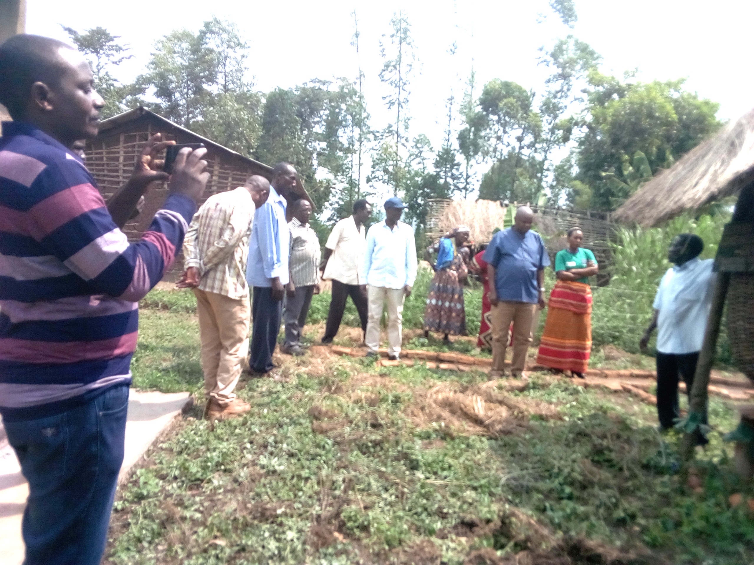 REV.FRED MUSIMENTA TAKING THE THE VISITORS AND COMMUNITY MEMBERS THROUGH A NEWSLY CONSTRUCTED GRANARY